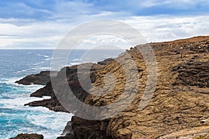 People walking on volcanic rocky at blowholes, Cape Bridgewater photo