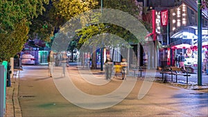 People are walking through walkways of the prater amusement park night timelapse in Vienna, Austria.