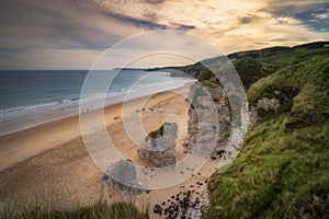 People walking on White Rocks Beach with limestone rock formations, Northern Ireland