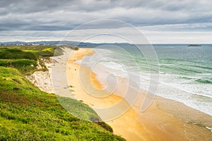 People walking on White Rocks Beach and swimming in the sea, Northern Ireland