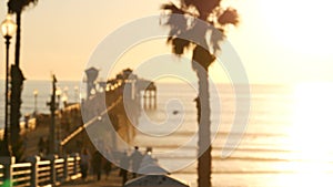 People walking, wooden pier in California USA. Oceanside waterfront vacations tourist resort.