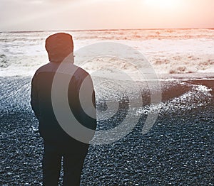 People walks on black sand beach of Reynisfjara in south of Iceland