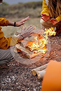 people warming hands above the bonfire. evening time, rest. Selective focus.