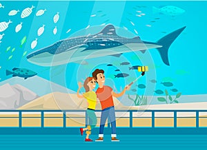 People watch underwater scenery with sea fauna in aquarium. Couple taking selfie with humpback whale