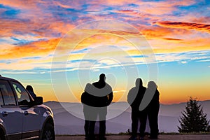 People watching a colorful sunset on a mountain vista