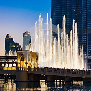 People watching Dubai fountains, illuminated trick fountains at night