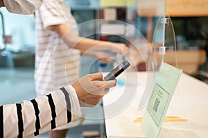 People wear face mask using the phone to scan QR code payment or register before entering and exiting in stores at the shopping