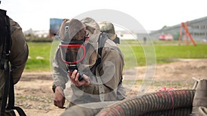 People wearing a Hazmat suit putting on a gas mask, Man in protective gas mask fastening protective chemical suit
