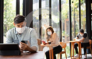 People wearing surgical masks are sitting in restaurants, coffee shops. social distancing concept Healthcare pandemic. Public photo