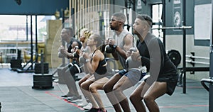 People, weightlifting and kettlebell in squat for workout, exercise or training together at gym. Group of active