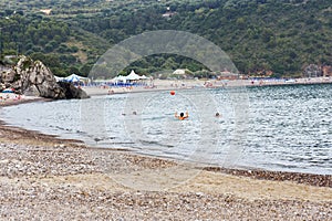 People who in the early evening still entertains on the beach. Bathing, amuse. photo