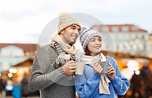 Happy couple drinking coffee at christmas market