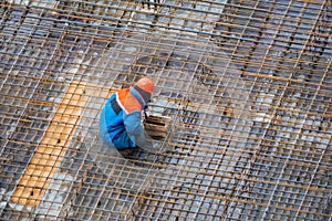 People work with reinforcement carcass made of fitness at construction site