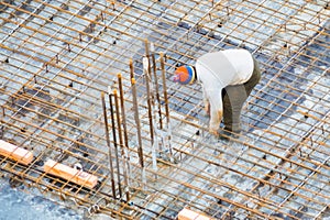 People work with reinforcement carcass made of fitness at construction site