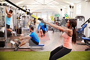 People working out on fitness equipment at a busy gym