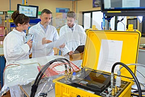 People in workshop electrical powerpack in foreground