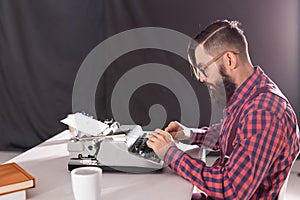 People, writer and hipster concept - young stylish writer working on typewriter