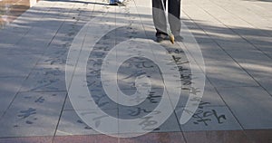 People wrting Buddhist scriptures on the ground with Chinese brush in Zhangye Gansu China