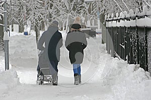 People, a young family park walk in the park in winter, snowfall in the park.