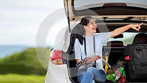 People young woman traveler and tourism holding map and pointing trips travel on hatchback car to destination leisure travel photo