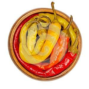 Peperoni pickles, pickled whole chili peppers in wooden bowl