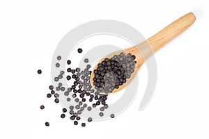 Black pepper seeds or peppercorns  dried seeds of piper nigrum in wooden spoon isolated on white