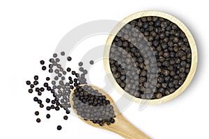 Close up black pepper seeds or peppercorns  dried seeds of piper nigrum in wooden bowl and spoon isolated on white