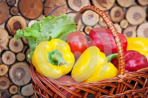 Pepper in basket on wooden spiled background. Harvest. With hay