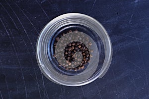 Pepper in bowl on black background