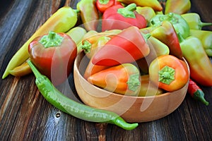 Pepper of different grades in a wooden background