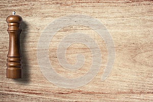 Pepper grinder on wooden background