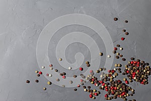 Pepper mix. Black, red and white peppercorns isolated on black stone background. Close-up, top view, copy space