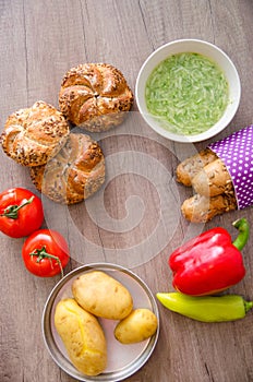 Pepper, potato, kaiser bun and baguette on wood table. Vegetarian bio food concept.