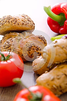 Pepper, potato, kaiser bun and baguette on wood table. Vegetarian bio food concept.