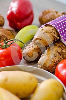 Pepper, potato, kaiser bun and baguette on wood table. Vegetarian bio food concept.