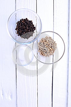 Pepper and salt in bowl on white background