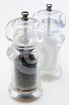 Pepper and salt grinders on white background