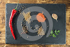 Pepper and spices top view on the background of slate