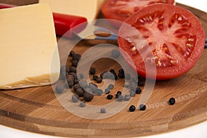 Pepper tomato and cheese on the kitchen board.