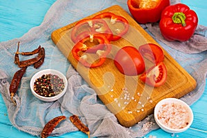 Pepper, tomato, salt, different spice on wooden background