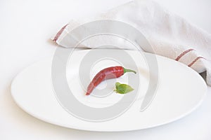 Pepper, white plate and a napkin