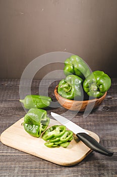 pepper on a wooden cutting board on dark table/fresh pepper on a wooden cutting board on dark table, selective focus