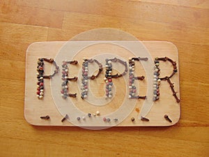 Pepper written on cutting board with pepper