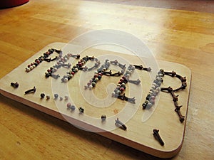 Pepper written on cutting board with pepper