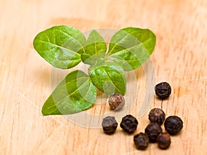 Peppercorn and greens on a wooden plate