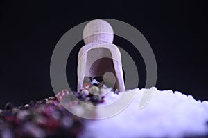 Peppercorns and coarse salt on a black background scattered on the surface