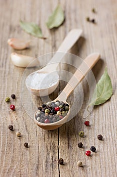 Peppercorns, sea salt in a wooden spoon with garlic