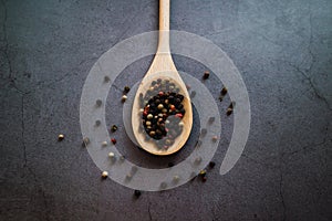 Peppercorns on wooden spoon. Seasoning product. Close up view