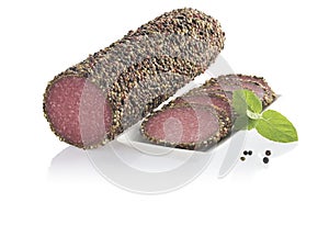 Peppered salami sausage with slices on white plate isolated on w