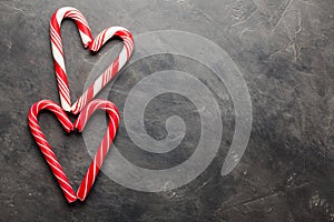 Peppermint Candy Canes in Heart Shapes on black concrete background. Christmas background. top view with copy space